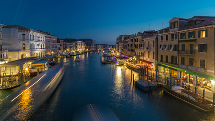 Fototapeta premium Grand Canal in Venice, Italy day to night timelapse. Gondolas and city lights from Rialto Bridge.