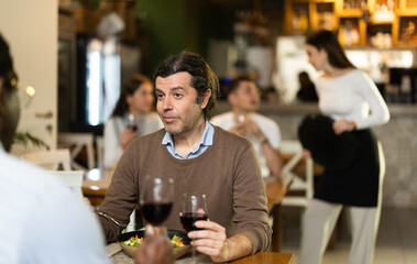 Men communicate at a business meeting in a restaurant. European talking to African man in restaurant