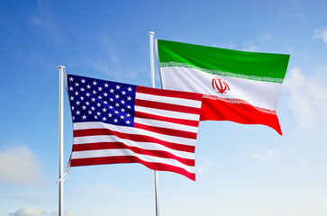 flags of united states of america and iran over blue sky background.