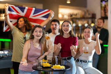 Emotional United Kingdom fans with the national flag watch the match on TV with interest and actively comment