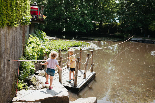 Kids using a raft or floater to go over a pond outdoors