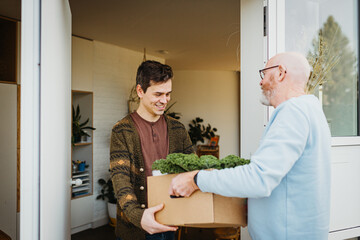 Food Courier Handing Over Food Delivery At The Door of a Family Home
