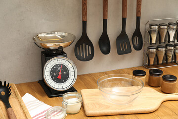 Retro mechanical kitchen scale and food products on wooden countertop indoors