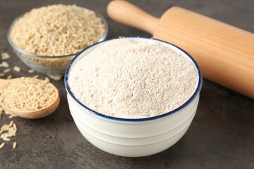 Brown rice and flour on grey table, closeup