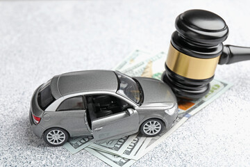 Motor vehicle accident law. Gavel, money and car model on grey background, closeup
