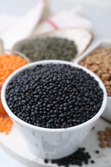 Different types of lentils on white table, closeup