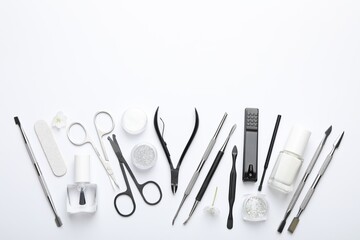 Set of different manicure tools on white background, flat lay. Space for text