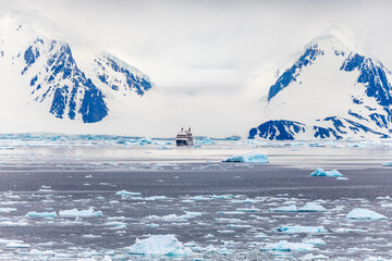 An Expedition Cruise Ship at the Dock in Ushuaia, Argentina, South America Against Backdrop of Snowclad Andes Mountains, Preparing for a Cruise to Antarctica