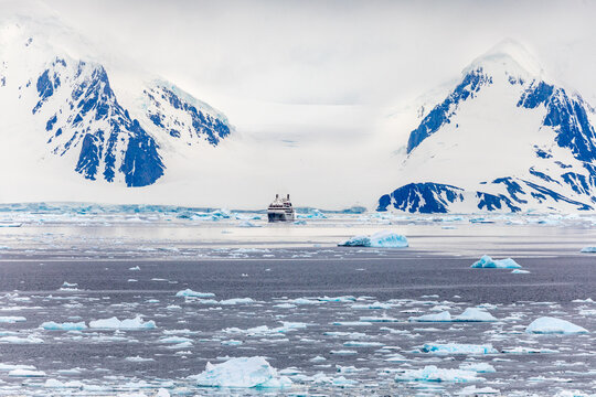 An Expedition Cruise Ship at the Dock in Ushuaia, Argentina, South America Against Backdrop of Snowclad Andes Mountains, Preparing for a Cruise to Antarctica - Powered by Adobe