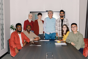 Photo of multiethnic team of IT company at table in open space office