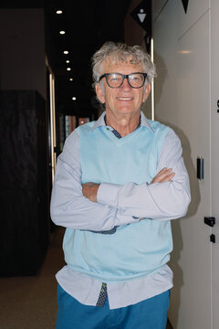 Front view of smiling elderly male IT company boss looking at camera