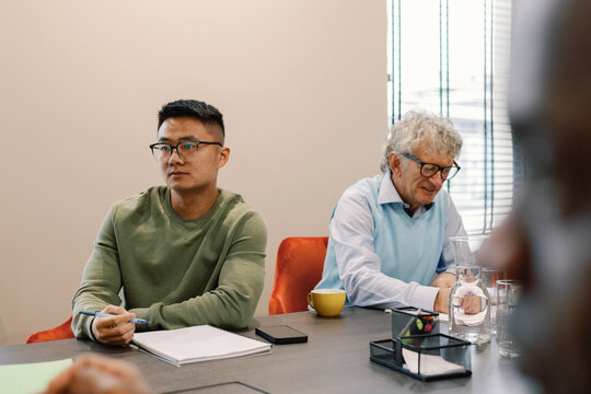 Young male multiracial IT company employees during meeting at table