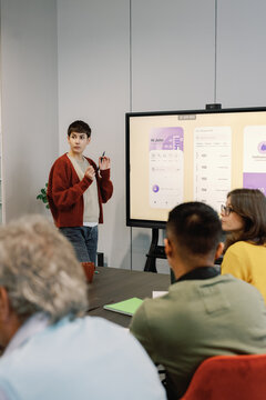 Woman listening someone during showing presentation to IT company team