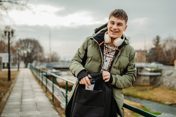 Fototapeta premium Portrait of young adult man student smile and use cellphone 