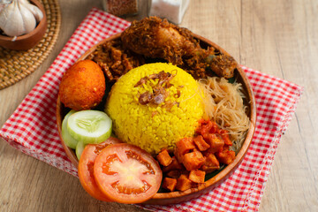 Nasi Kuning. Yellow rice is a typical Indonesian food. This food is made from rice cooked with turmeric, coconut milk, spices and served with fried chicken, egg balado, sambal, and crackers. 