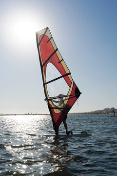 Windsurfer Gliding Across Ocean at Sunset