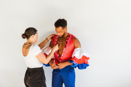 A girl helps a dancer get dressed