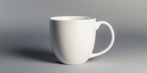 Fototapeta premium Elegant white ceramic mug on a soft gray background showcasing minimalistic design, perfect for coffee or tea, ideal for branding and product photography, beverage concept