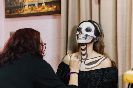 Woman doing horror-themed makeup for Hallowee