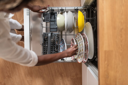 Woman putting plates in dishwasher