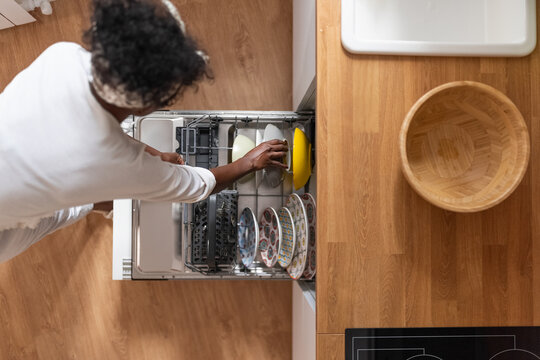 Woman using dishwasher while doing chores
