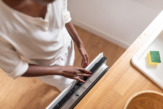 Woman selecting program on dishwasher