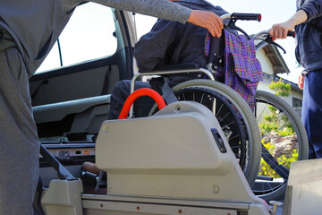 介護タクシーに高齢者を乗せる介護士 © 琢也 栂