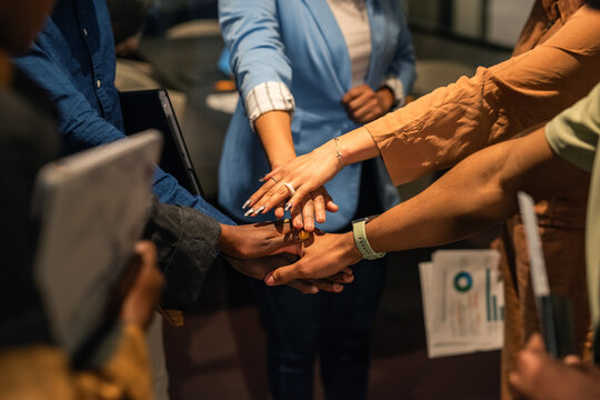 Group of people staking hands at meeting room