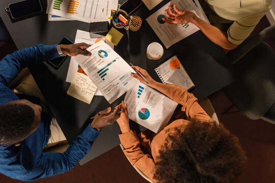Businesspeople exchanging documents at meeting room