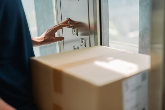Delivery man pressing button in elevator
