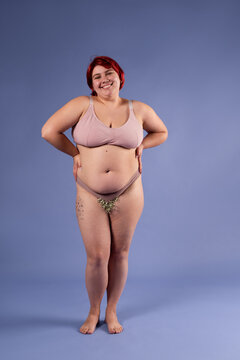Full body plus size woman in underwear posing at studio 