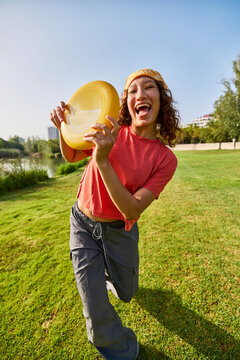 Happy woman with frisbee in park