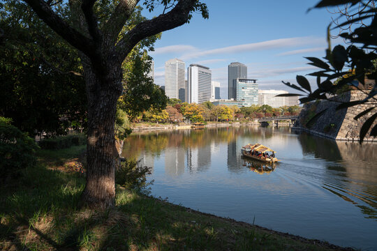 Tourist boat at river surrounded by skyscrapers in Osaka, Japan