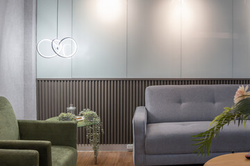 Calm waiting room interior with modern furniture. Features sofa, armchairs, wood accents, textured walls, and stylish decor. Ideal for relaxation or reception