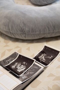 Pregnant woman looking at sonogram photos in her bedroom 
