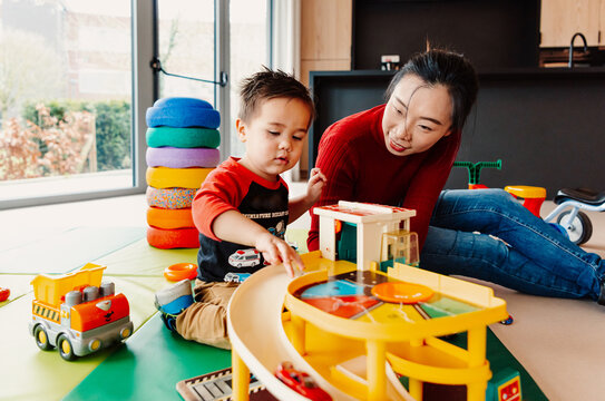 Loving mother with son at childcare playroom, encouraging him