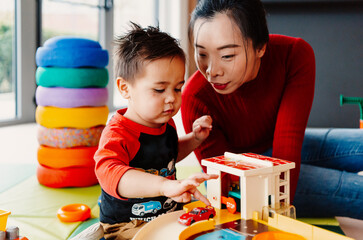 Mother stimulating baby boy play