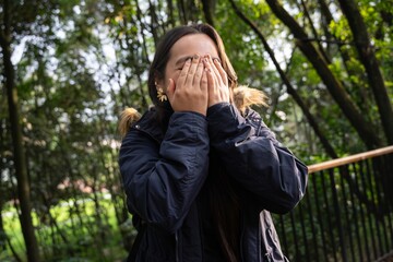 Fototapeta premium Young woman breathing pure air in a forest. Portrait of a Woman Hiker Smiling