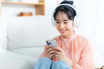 部屋で音楽を聴く若い女性