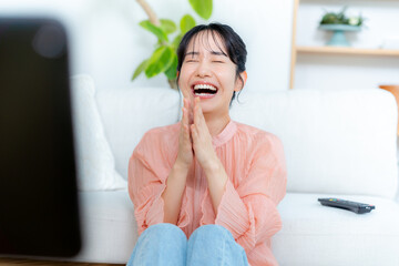リビングでテレビを見る若い女性