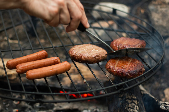 Burgers and Hot Dogs Grilling over Camp Fire
