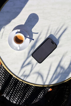 Blank screen phone and coffee over classic french coffee table