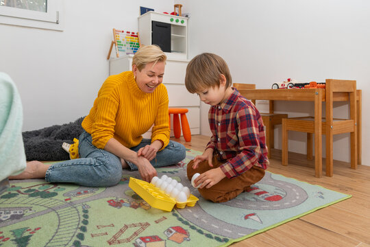 Mom and her autistic child playing with Montessori Egg Sorter