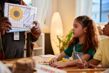 Teacher showing number 2 to students in class