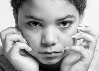 A young African American girl stares at the camera. 