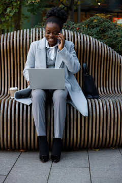 Female freelancer working while sitting on bench in park 