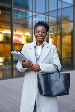 Real estate agent standing near office building waiting for client