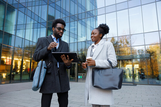 Startup founder presenting project to investor near office entrance