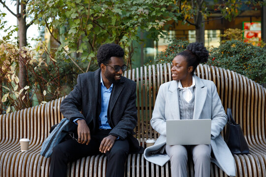 Co-workers brainstorming ideas for new project at coffee break in park