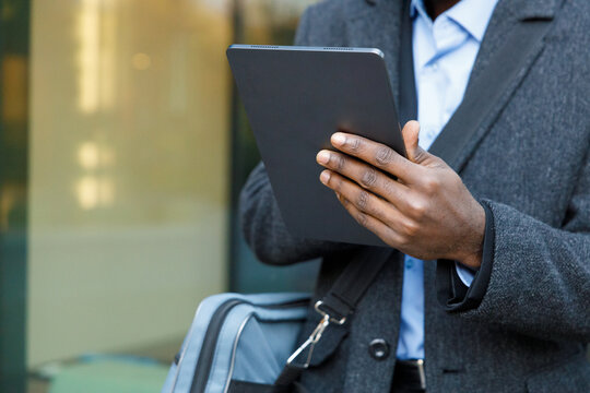 Closeup image of anonymous trader working on tablet in street